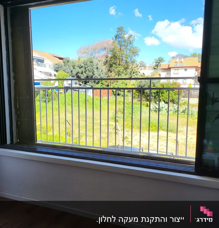 חלון עם מסגרת מתכת ונוף חיצוני